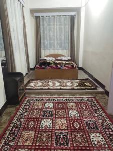 Habitación con cama y alfombra en el suelo en DukeRaj Homestay en Darjeeling