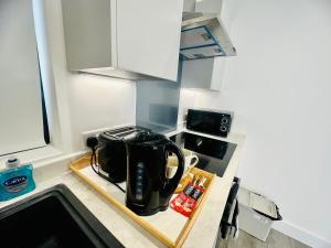 eine Küche mit einer Kaffeekanne auf der Theke in der Unterkunft Hemel Apartments- Sunset retreat in Hemel Hempstead
