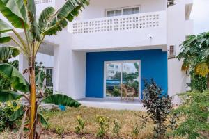 a house with a blue door in the yard at Amani Cottage in Dambani