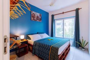 niebieska sypialnia z łóżkiem i oknem w obiekcie Amani Cottage w mieście Dambani