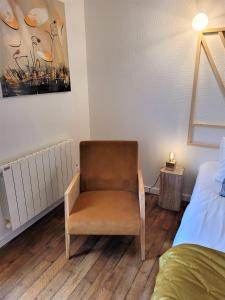 ein Schlafzimmer mit einem Stuhl und einem Bett in der Unterkunft Terrasse Godrans en plein cœur de ville in Dijon