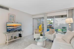 a living room with a white couch and a tv at Sea Gem 803 in Naples
