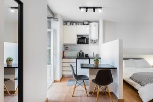 a small apartment with a bed and a desk and chairs at Coreto Garden in Vila do Conde