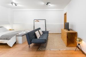 a bedroom with a bed and a blue couch at Coreto Garden in Vila do Conde