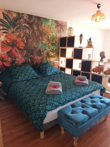 1 dormitorio con 1 cama con sofá y un mural en Appartement Bilimbi Guadeloupe entre Sainte-Anne et Saint-François, en Sainte-Anne