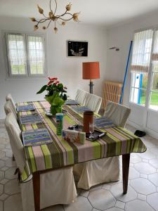 a table with chairs and a table cloth on it at Chez Bernard pavillon proche Disneyland et Paris in Coulommiers