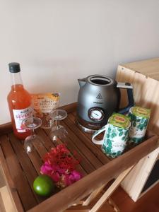 uma prateleira de madeira com comodidades para preparar café e copos de vinho em Appartement Bilimbi Guadeloupe entre Sainte-Anne et Saint-François em Sainte-Anne