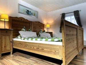 ein großes Holzbett in einem Schlafzimmer mit Fenster in der Unterkunft FeWo Marie im Ferienhaus Selma in zentraler Lage in Großschönau