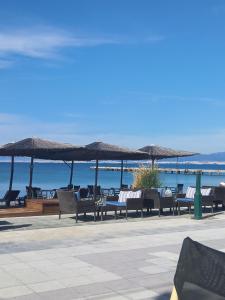 a group of chairs and umbrellas on the beach at Alas House in Agia Triada