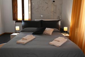 コゼンツァにあるPalace Eight - Suites & Spaのベッドルーム1室(ベッド1台、タオル2枚付)