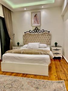 ein Schlafzimmer mit einem großen Bett mit einem großen Kopfteil in der Unterkunft Alexandria Luxury Apartments Gleem 2 Direct Sea View in Alexandria