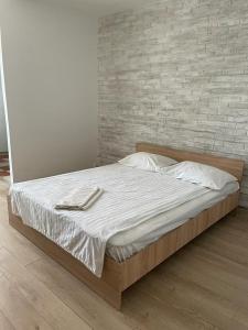 łóżko w sypialni z ceglaną ścianą w obiekcie Bega Cirumvalatiunii One Room Apartment- 4 w mieście Timişoara