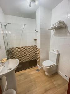 uma casa de banho com um WC, um lavatório e um chuveiro em Hostal La Frontera em Ferrol