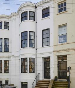 een wit gebouw met zwarte ramen bij The Cobbles in Filey