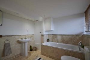 een badkamer met een wastafel, een bad en een toilet bij The Cobbles in Filey