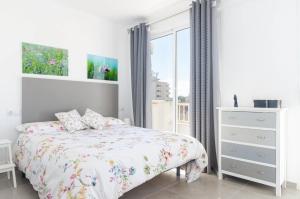 a white bedroom with a bed and a window at YourHouse Monges sea view Studio in Can Picafort
