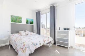a white bedroom with a bed and a window at YourHouse Monges sea view Studio in Can Picafort