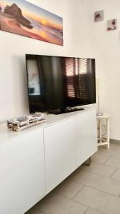 einen Fernseher auf einem weißen Unterhaltungszentrum in der Unterkunft DGS APARTHOTEL in Trapani