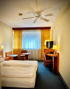 フランクフルト・アム・マインにあるサヴォイ ホテルのベッドとテレビが備わるホテルルームです。