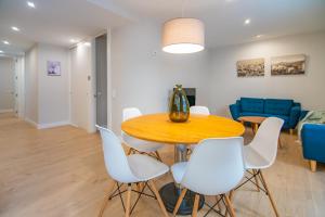 a dining room with a table and white chairs at Apartamento junto al ayuntamiento de Santander in Santander
