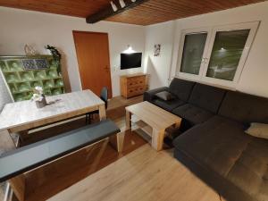 uma sala de estar com um sofá e uma mesa em Michas Lahn Ferienwohnung 