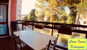 d'une table et de chaises blanches sur un balcon avec fenêtre. dans l'établissement Casa Imma, à Desenzano del Garda