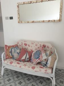 - un canapé avec des oreillers dans le salon dans l'établissement Dimora Quattro Vanelle, à Favignana