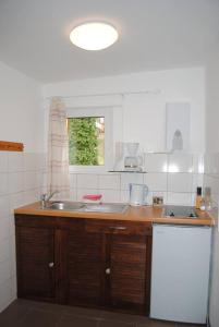 eine Küche mit einer Theke, einem Waschbecken und einem Fenster in der Unterkunft Bungalows Zur Alten Fähre in Werder