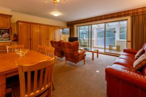 sala de estar con mesa y sofá en Loch Rannoch Highland Club en Kinloch Rannoch