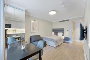 伦敦Cleveland Residences Paddington的一间带床和桌子的酒店房间