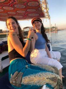 dos mujeres sentadas en un barco en el agua en Nour El Balad, en Luxor