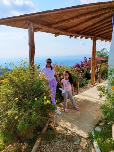 a woman and a little girl standing under a roof at Cabañas Mirador La Roca in Melgar +33 photos