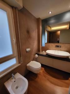a bathroom with a sink and a toilet and a mirror at Greige Apartment in La Spezia