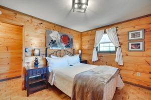 ein Schlafzimmer mit einem Bett in einem Zimmer mit Holzwänden in der Unterkunft Central Sevierville Cabin with Hot Tub and Views! in Sevierville