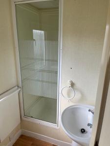 a bathroom with a glass shower and a sink at 604 Seawick in Jaywick Sands