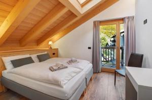Schlafzimmer mit einem Bett, einem Schreibtisch und einem Fenster in der Unterkunft Olympic Chalet in Bormio