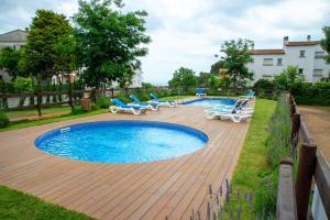 una piscina con sillas y una terraza de madera en Kampaoh Calella de Palafrugell en Palafrugell