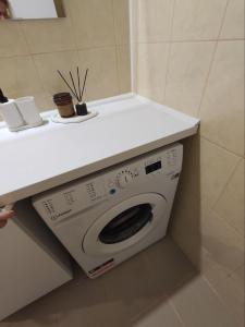 een wasmachine onder een aanrecht in een badkamer bij LK Apartment in Rēzekne