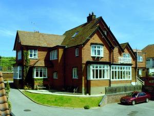 una casa con un coche rojo estacionado frente a ella en Camberley House en Sheringham