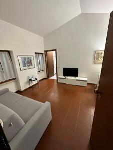 a living room with a couch and a flat screen tv at Dreaming Borgo Roma Apartment in Verona