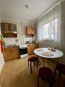 Spacious 3-Room Apartment & Parking في ريغا: مطبخ مع طاولة وكرسيين وطاولة