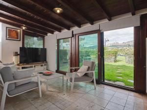a living room with a tv and chairs and windows at UNICA Assisi agri-charming house in Assisi