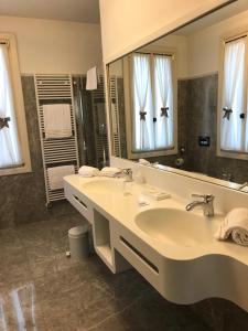 een badkamer met een wastafel en een grote spiegel bij Hotel Donna Lucia in Ponzano Veneto