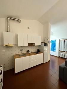 a kitchen with white cabinets and a sink at Dreaming Borgo Roma Apartment in Verona
