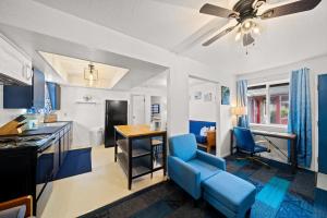 een keuken en een woonkamer met blauwe stoelen en een plafondventilator bij Surf & Sand Inn in Pacific City