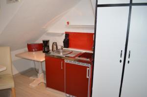 a small kitchen with a sink and a table at Ferienwohnung Meersburg 30m vom Bodensee in Meersburg +5 photos