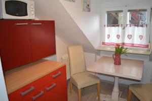 Habitación pequeña con armario rojo y mesa. en Ferienwohnung Meersburg 30m vom Bodensee, en Meersburg