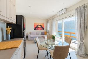 cocina y sala de estar con mesa de cristal y sillas en Sunset Dreams Spyros, en Kalymnos