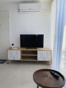 una sala de estar con TV en un centro de entretenimiento de madera en Un T3 chaleureux à proximité du Dôme et du métro, en Marsella