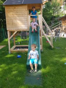 dwoje dzieci zjeżdżających ze zjeżdżalni na placu zabaw w obiekcie Haus Margret w mieście Stummerberg